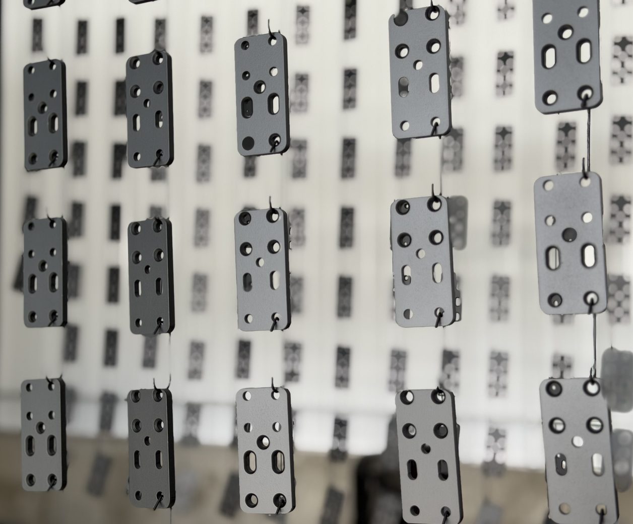 Powder coated hardware brackets on the hang line at Proper Powder Coating in Ogden, Utah